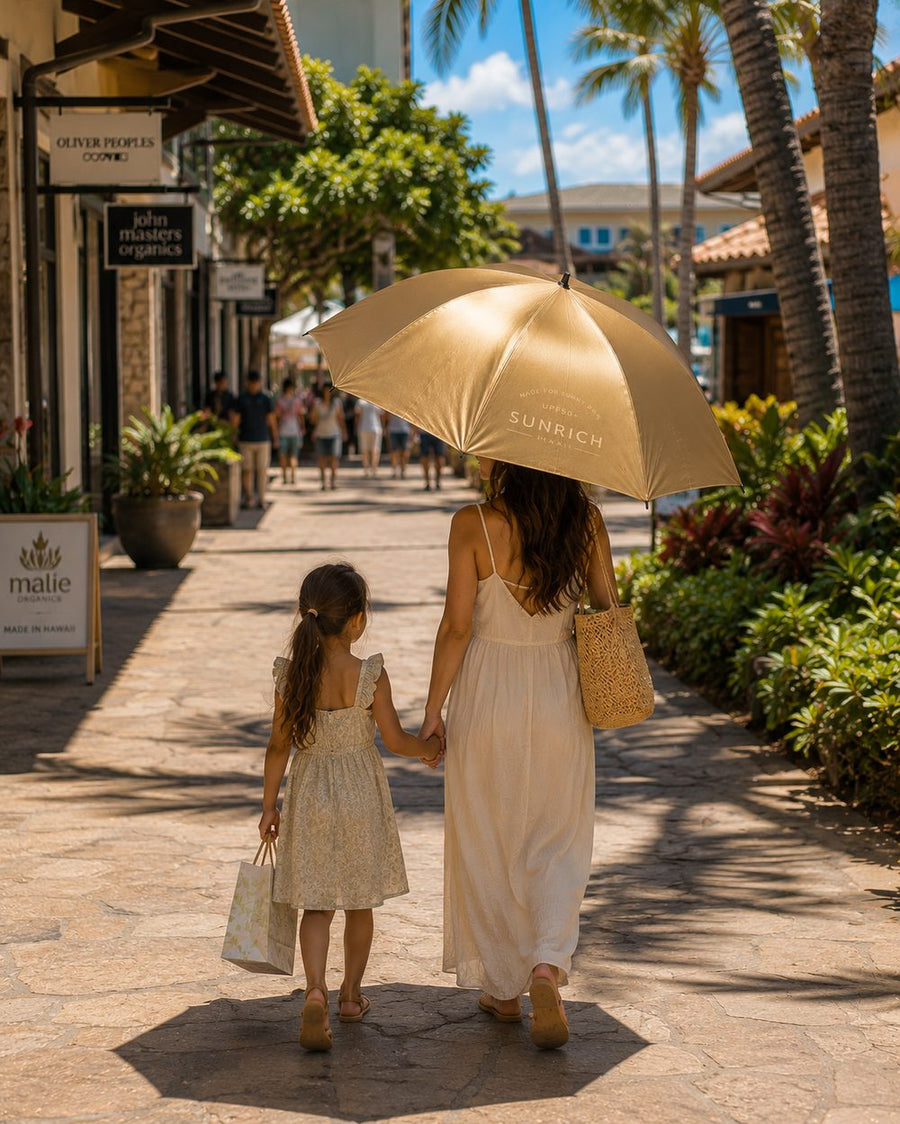 A mother and daughter walk hand in hand through an open-air shopping street beneath the gold SUNRICH Sun Shade